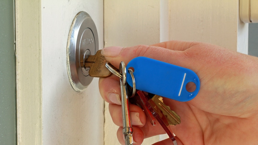 Woman opens a door with a key