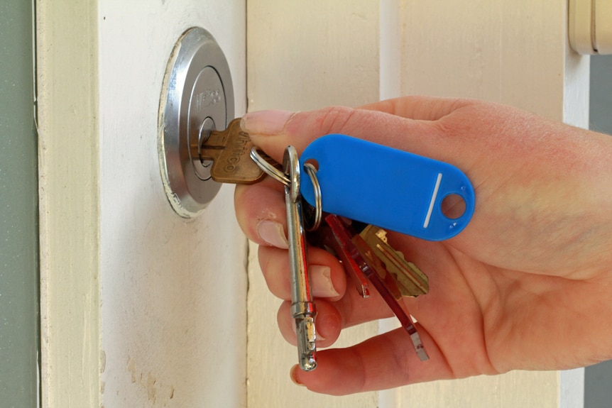 La femme ouvre une porte avec une clé