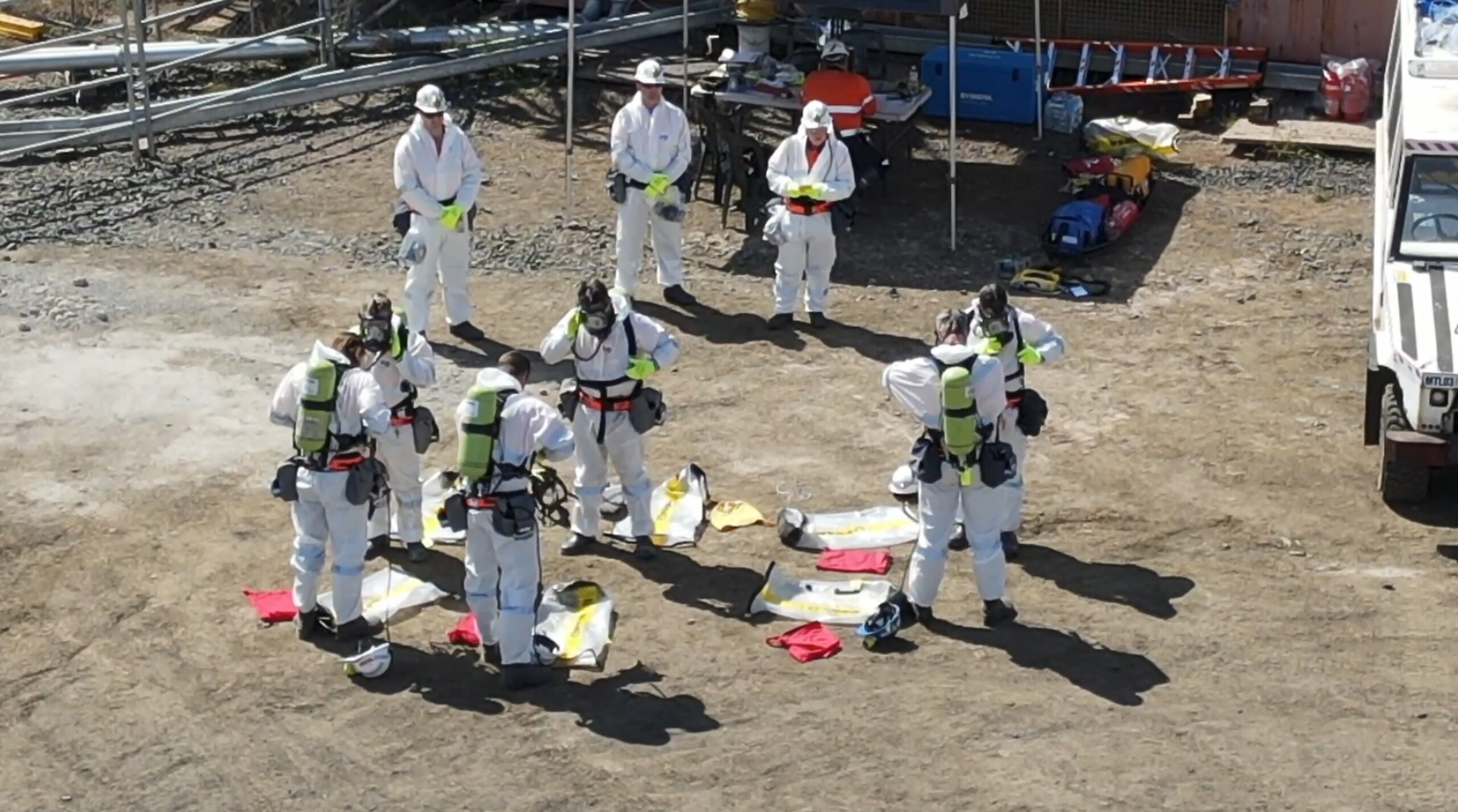 Un grupo de personas en un patio, poniéndose ropa blanca pesada. 