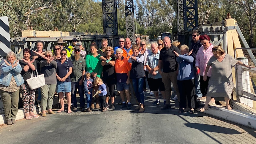 A large group of people standing on a bridge.