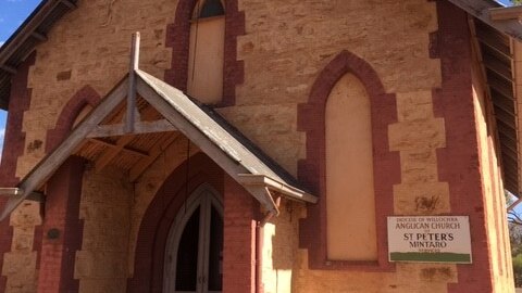 A traditional church, constructed from clay coloured sandstone and detailed with red bricks.