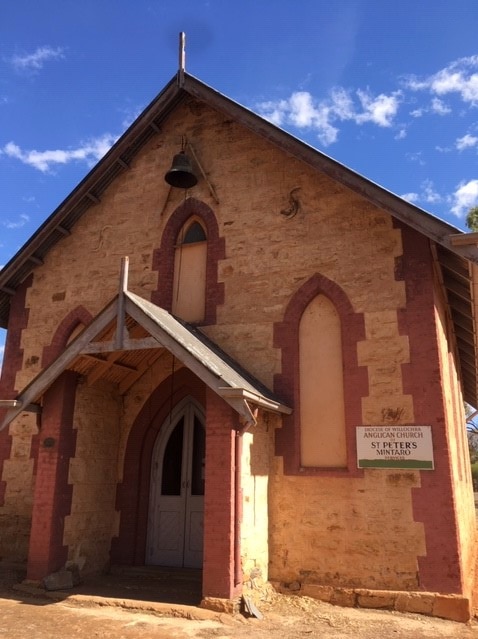 A traditional church, constructed from clay coloured sandstone and detailed with red bricks.