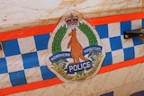 NT Police insignia on mud-splattered car door.
