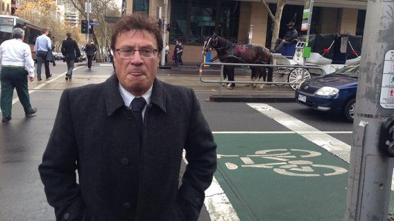 A man in a suit walking across an intersection.