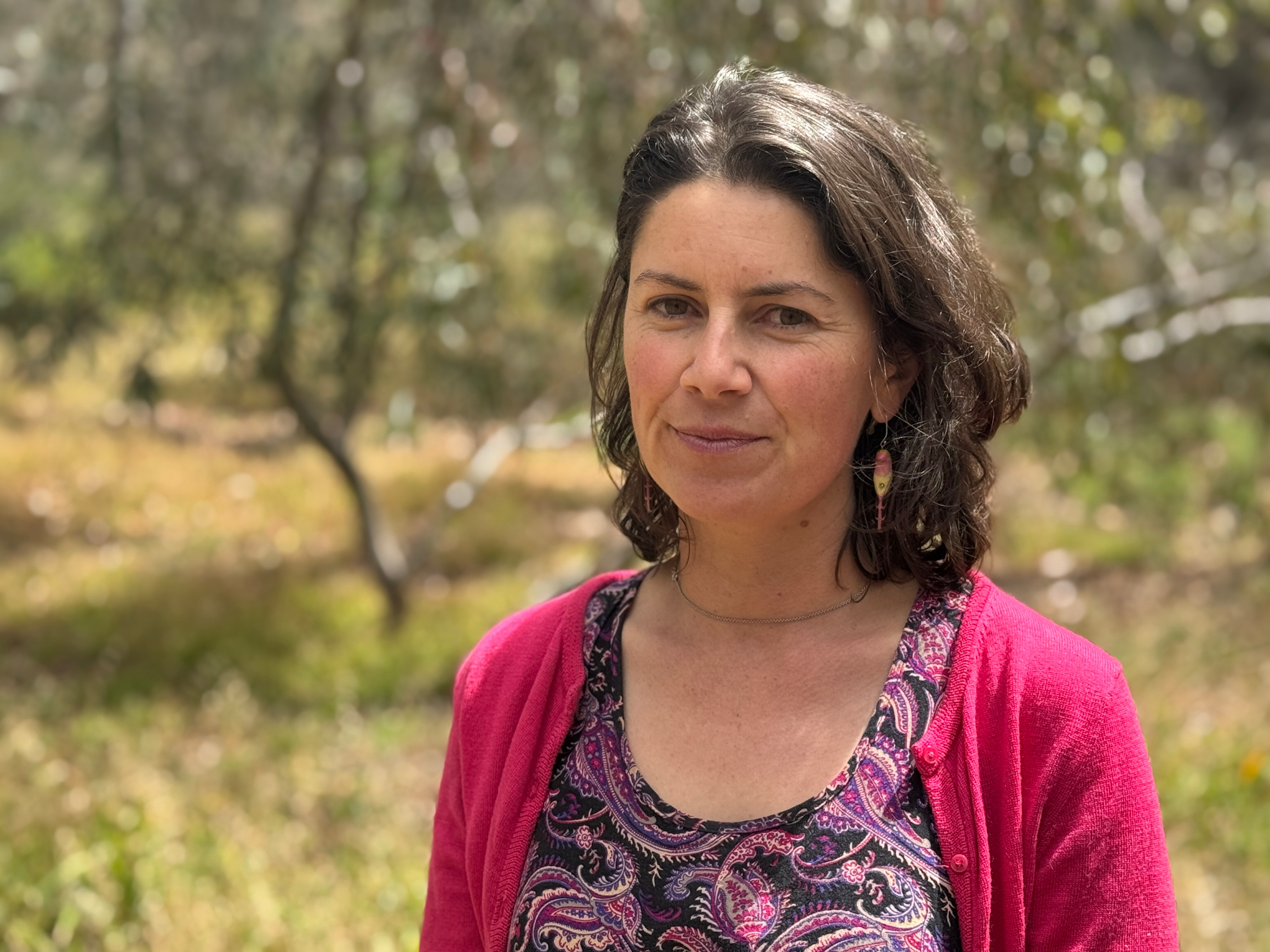 Una mujer con el pelo corto y castaño se encuentra en el monte.