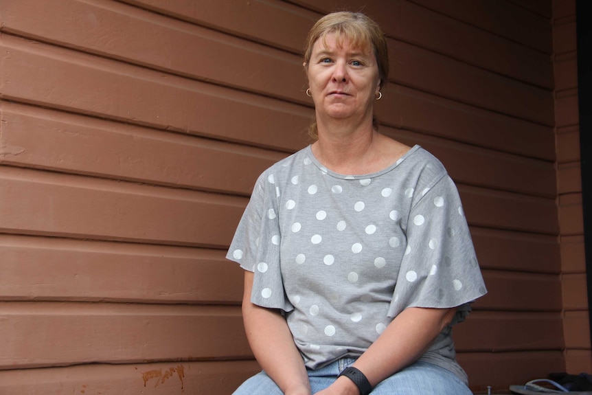 A woman sits on a step