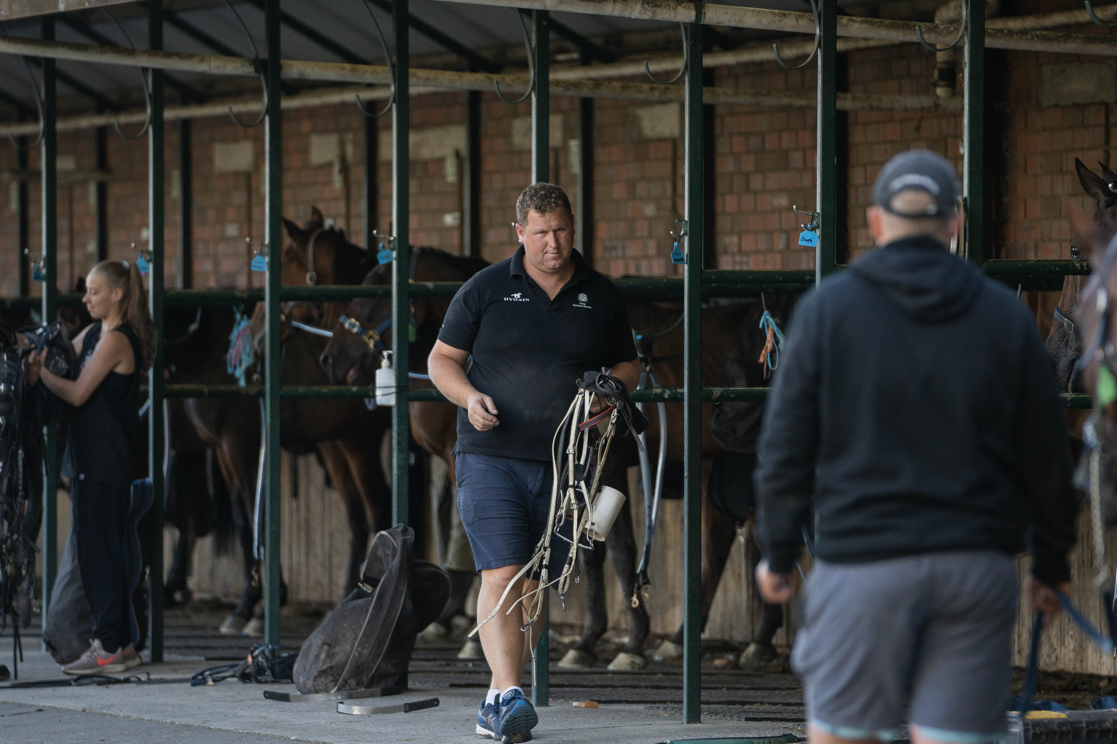 A man holds a bunch of bridles.