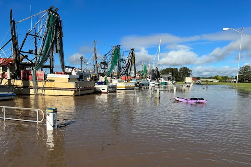 Fishing trawlers in a harbour flooded by water.