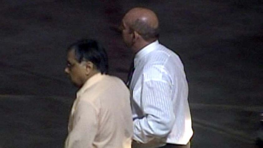 Former Bundaberg surgeon Jayant Patel being escorted onto a Qantas jet in LA