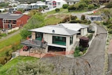 A balcony looks twisted with the driveway is cracked after a landslip.