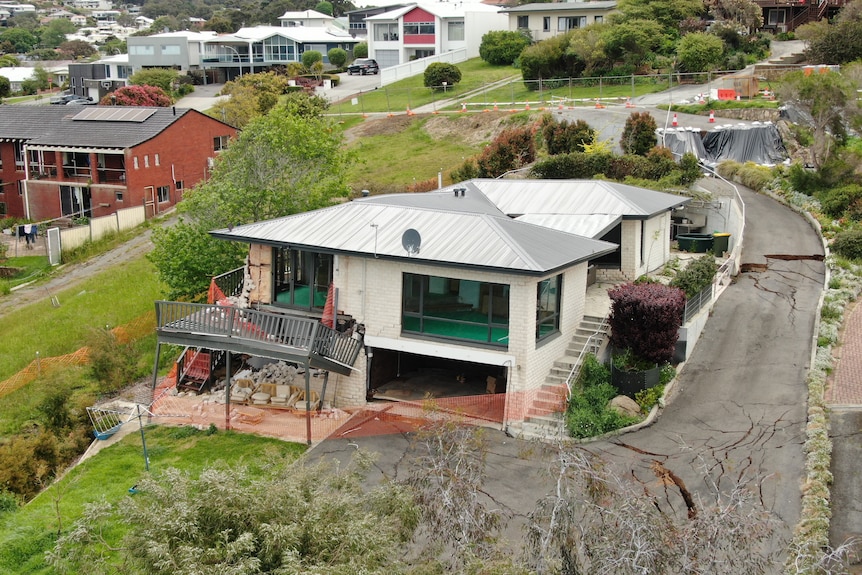 A balcony looks twisted with the driveway is cracked after a landslip.