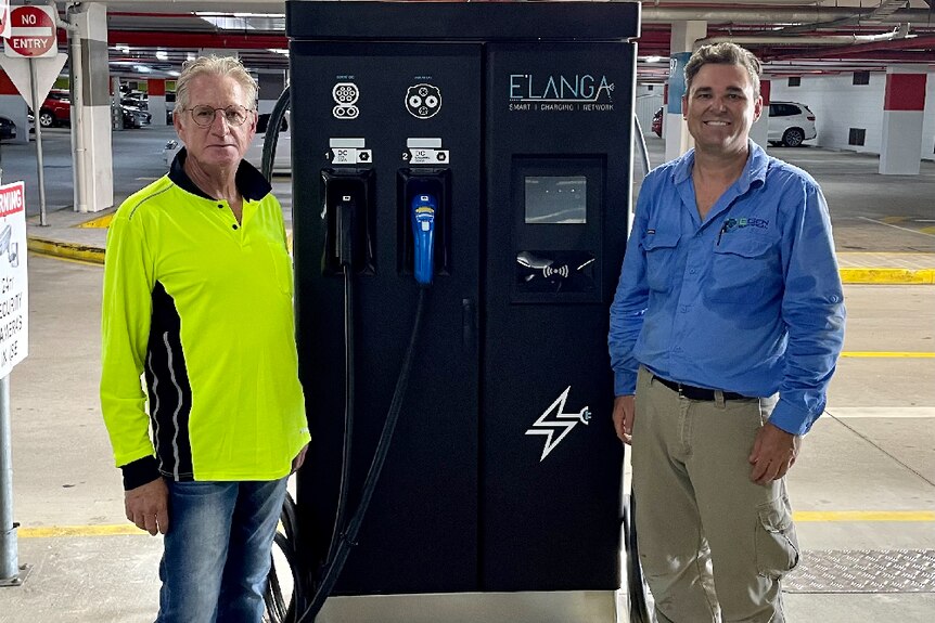Billy Wepener CEO standing with another man beside a car charging station in a carpark