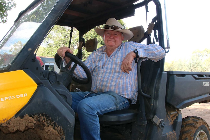 A man, Blue Bredhauer, is sitting in a muddy RTV, looking at the camera.