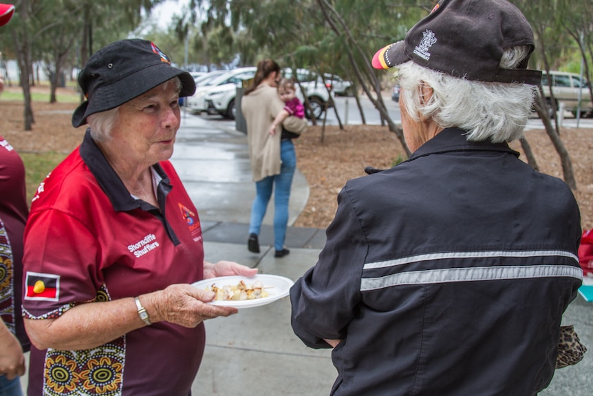 Two walkers chat while eating a meal.