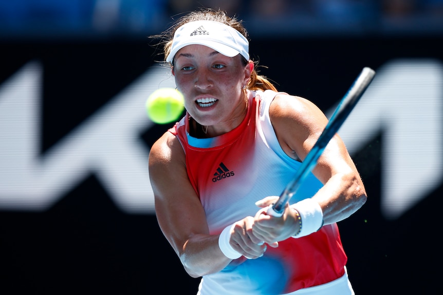 An American female tennis player hits a backhand return.