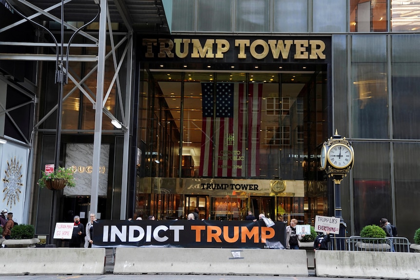 Protesters hold a sign saying "INDICT TRUMP" in front of Trump Tower in New York