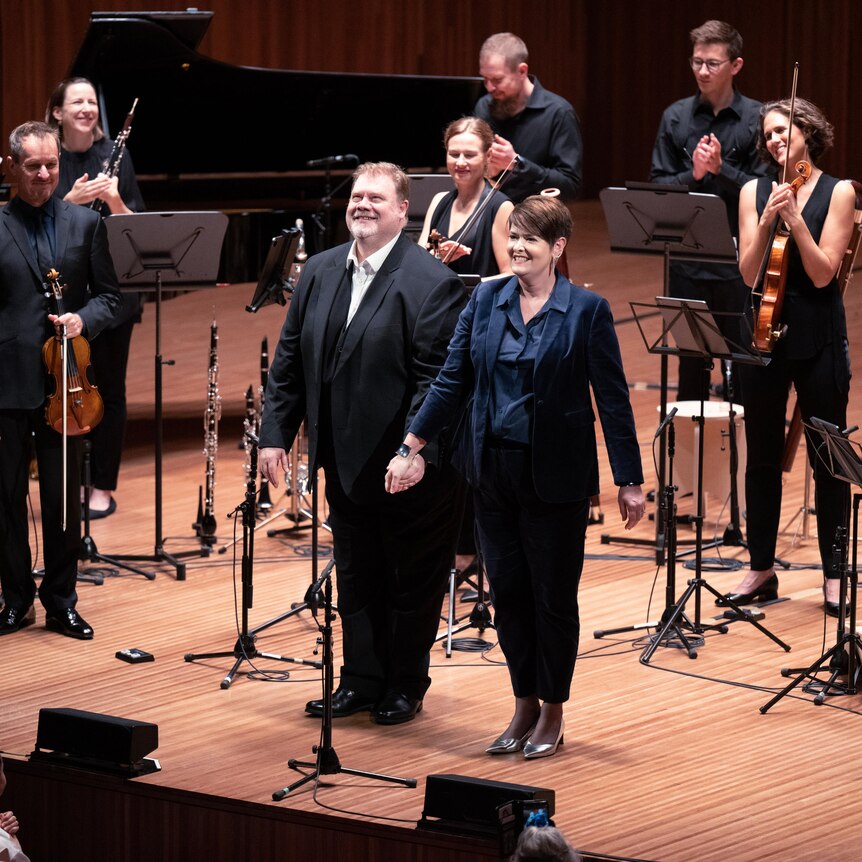 Mezzo-soprano Catherine Carby and tenor Stuart Skelton taking a curtain-call on stage with members of the ACO.