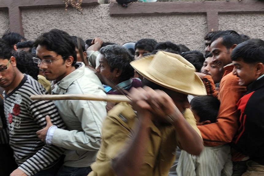 Indian policemen used bamboo sticks to keep order in the rush for tickets.