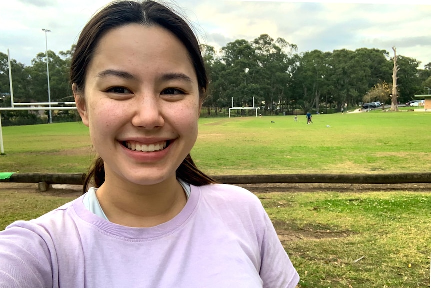 Angela smiles in a selfie taken at a park, for a story about the benefits of hobbies.