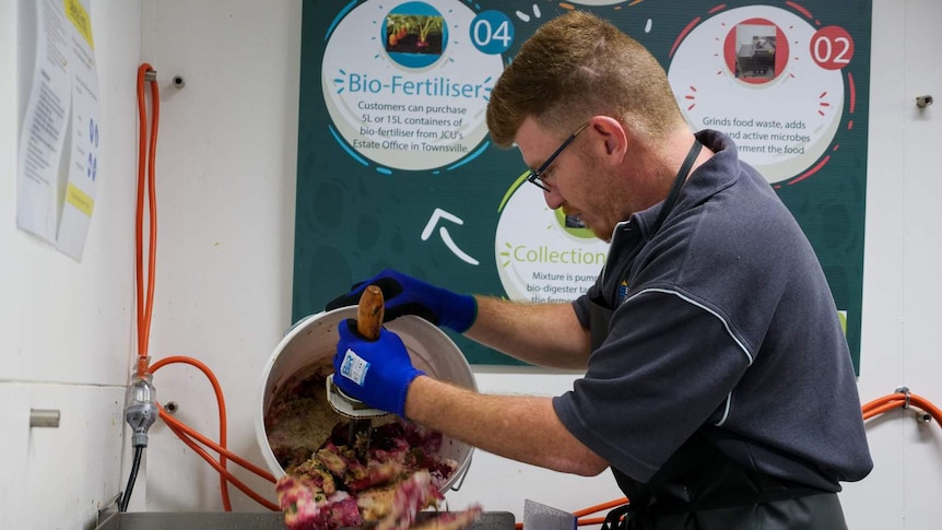 A university staff member pours food waste into the Bio-Regen machine.