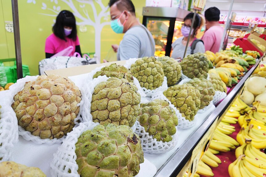 在一个水果摊位上摆放着待售的台湾释迦