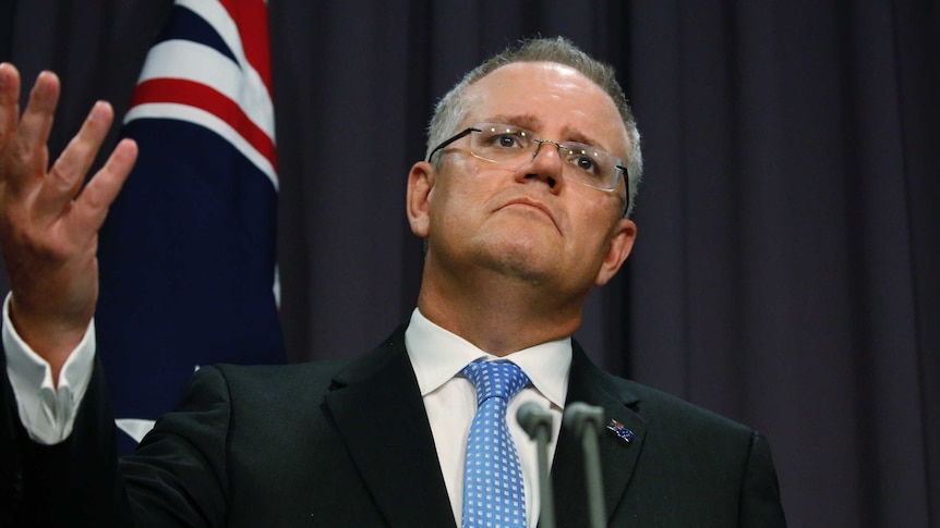 Treasurer Scott Morrison gestures with his right hand at a press conference,