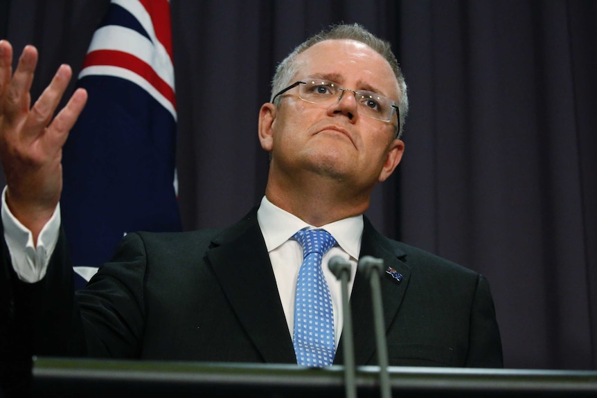 Treasurer Scott Morrison gestures with his right hand at a press conference,