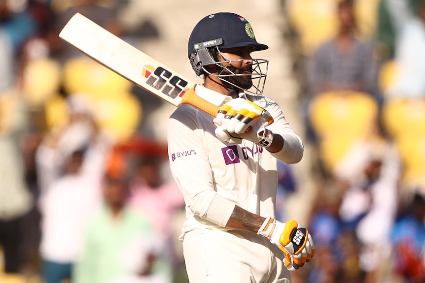 An Indian male batter celebrates scoring a half-century against Australia.