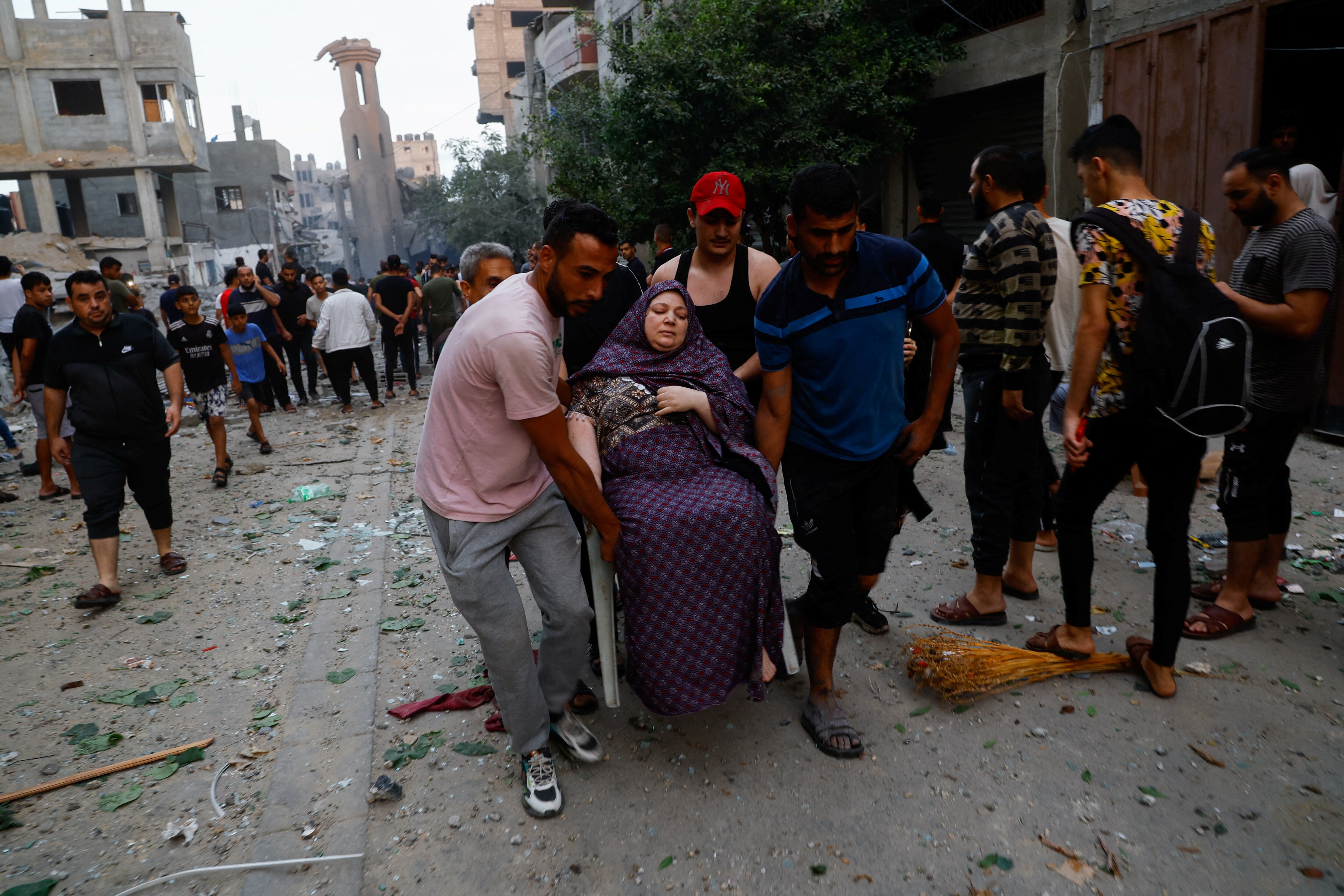 People support woman injured with crowd behind them 