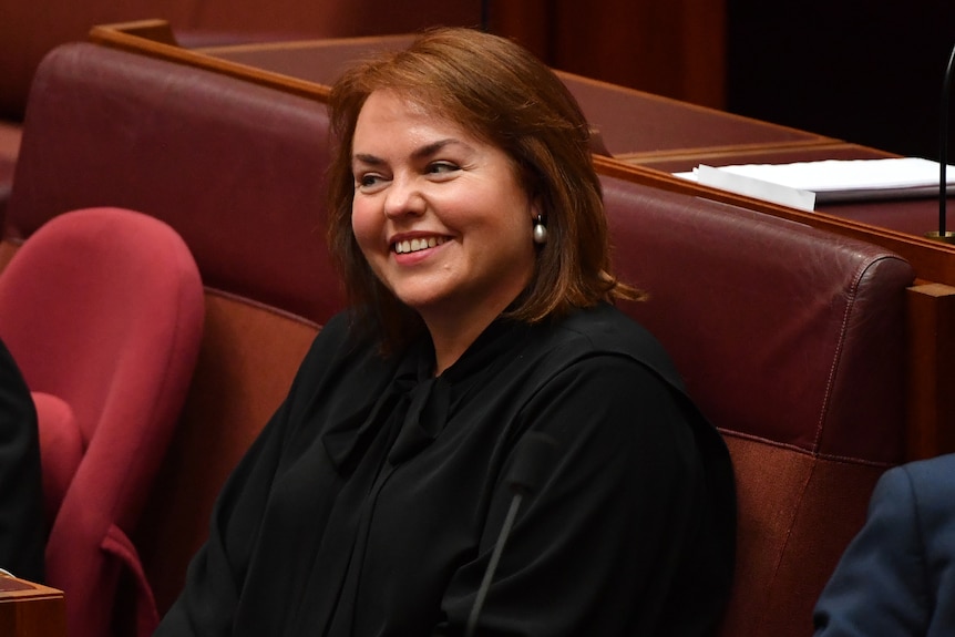 A candid photo of Kimberley smiling as she sits in the senate.