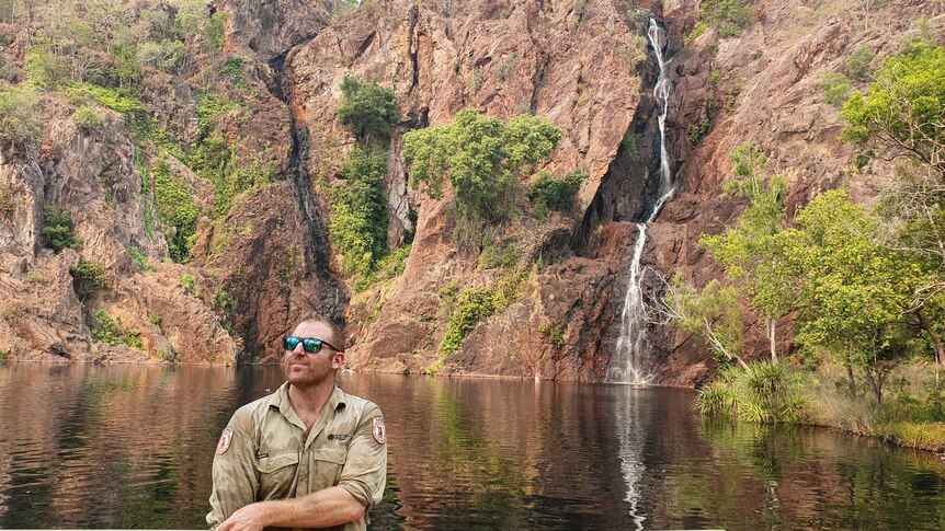 Litchfield Park ranger standing in front of waterfall.