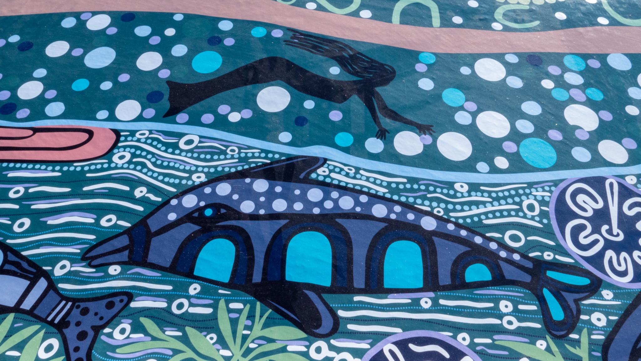 Uma pintura mural de uma sereia e um golfinho na água.