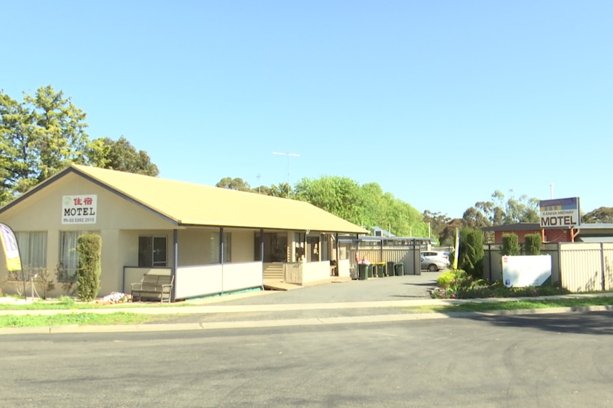 A roadside motel. The sun is shining brightly.