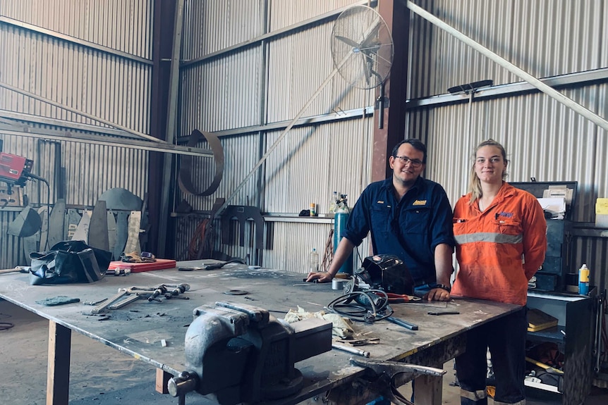 Two people standing in an engineering workshop