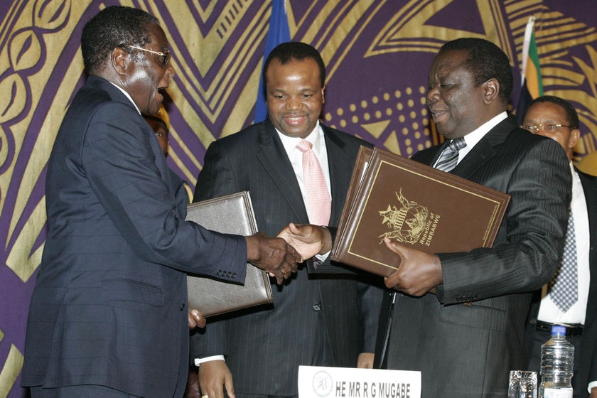 Zimbabwe's President Robert Mugabe shakes hands with opposition leader Morgan Tsvangirai