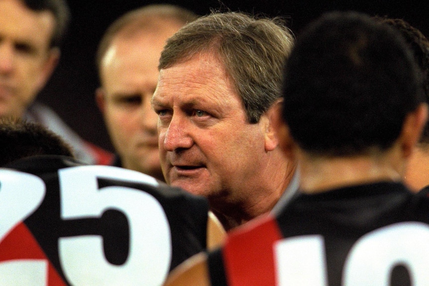 An archive photo of Kevin Sheedy speaking to Essendon players in a huddle in 2000.