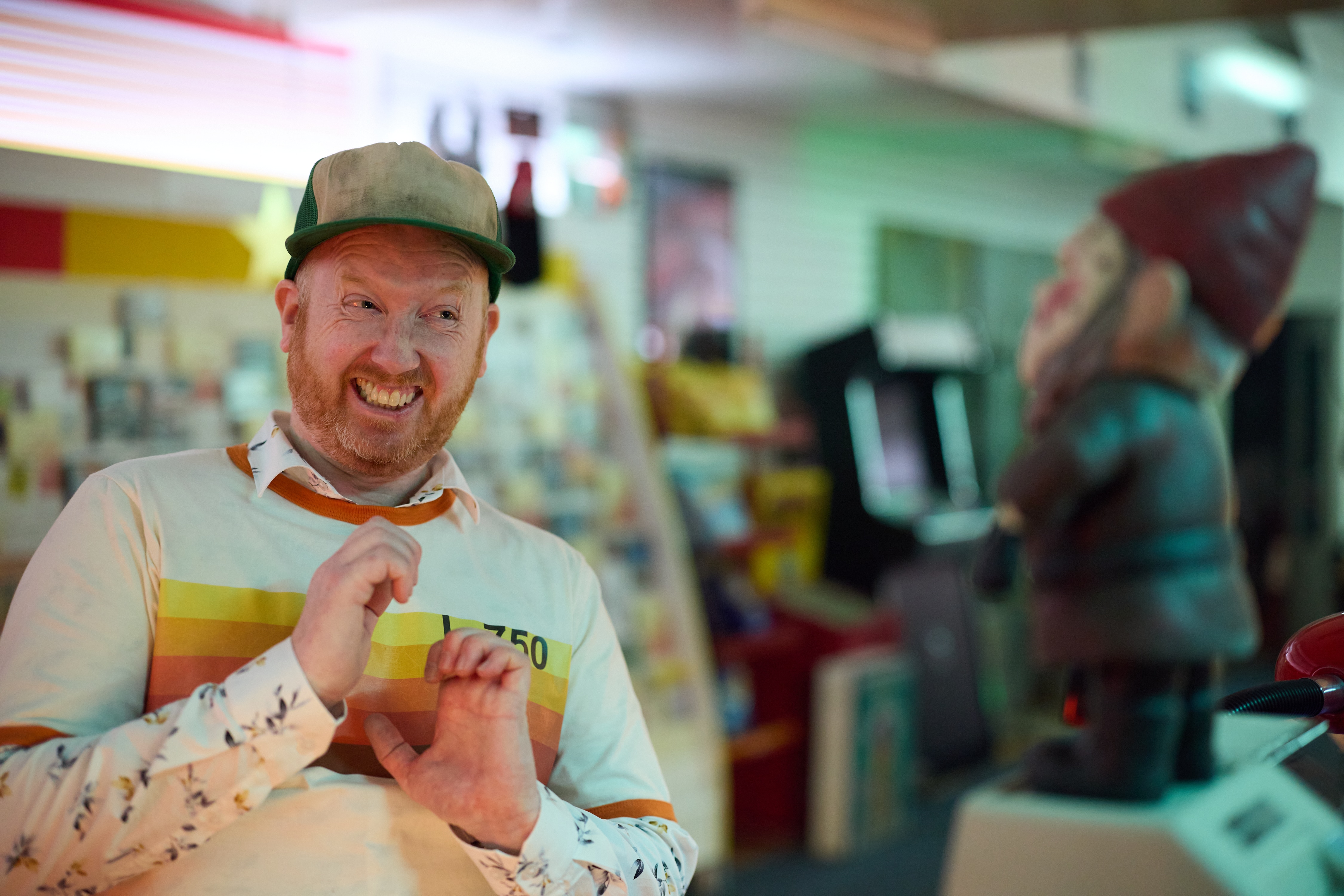 A man cringes towards a gnome in a video store