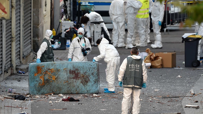 Forensics police looking at blood-stained mattress