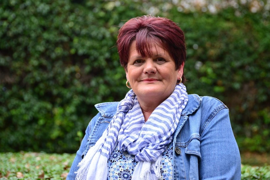 A portrait of a woman wearing a blue scarf.