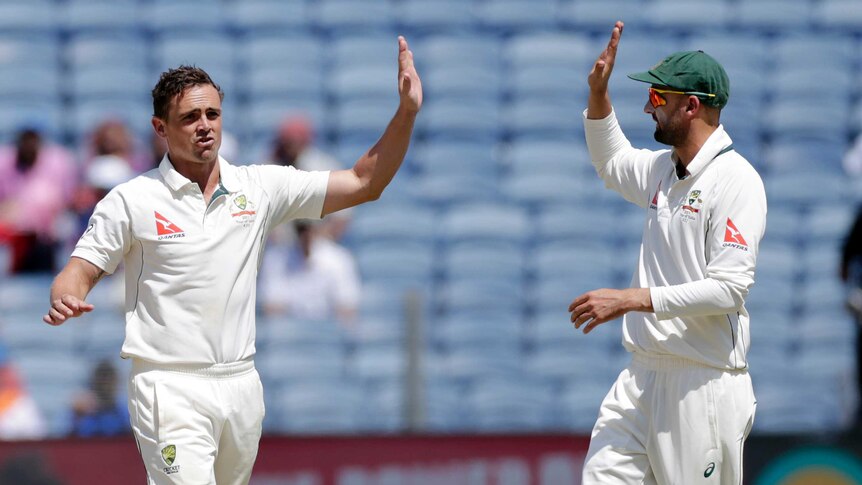 Steve O'Keefe and Nathan Lyon high five in Pune