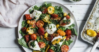 A plate of caprese salad with oven roasted tomatoes, basil gremolata and buffalo mozzarella, to serve for dinner.