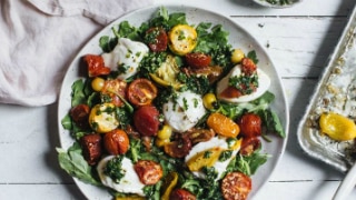 A plate of caprese salad with oven roasted tomatoes, basil gremolata and buffalo mozzarella, to serve for dinner.