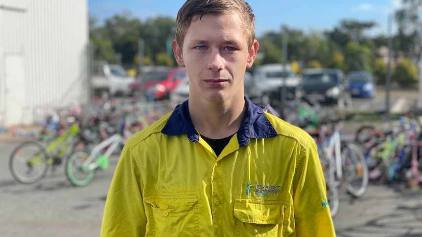 A young man in a high vis shirt looks at the camera