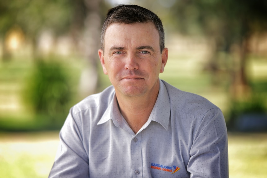 A man wearing a grey collared shirt.