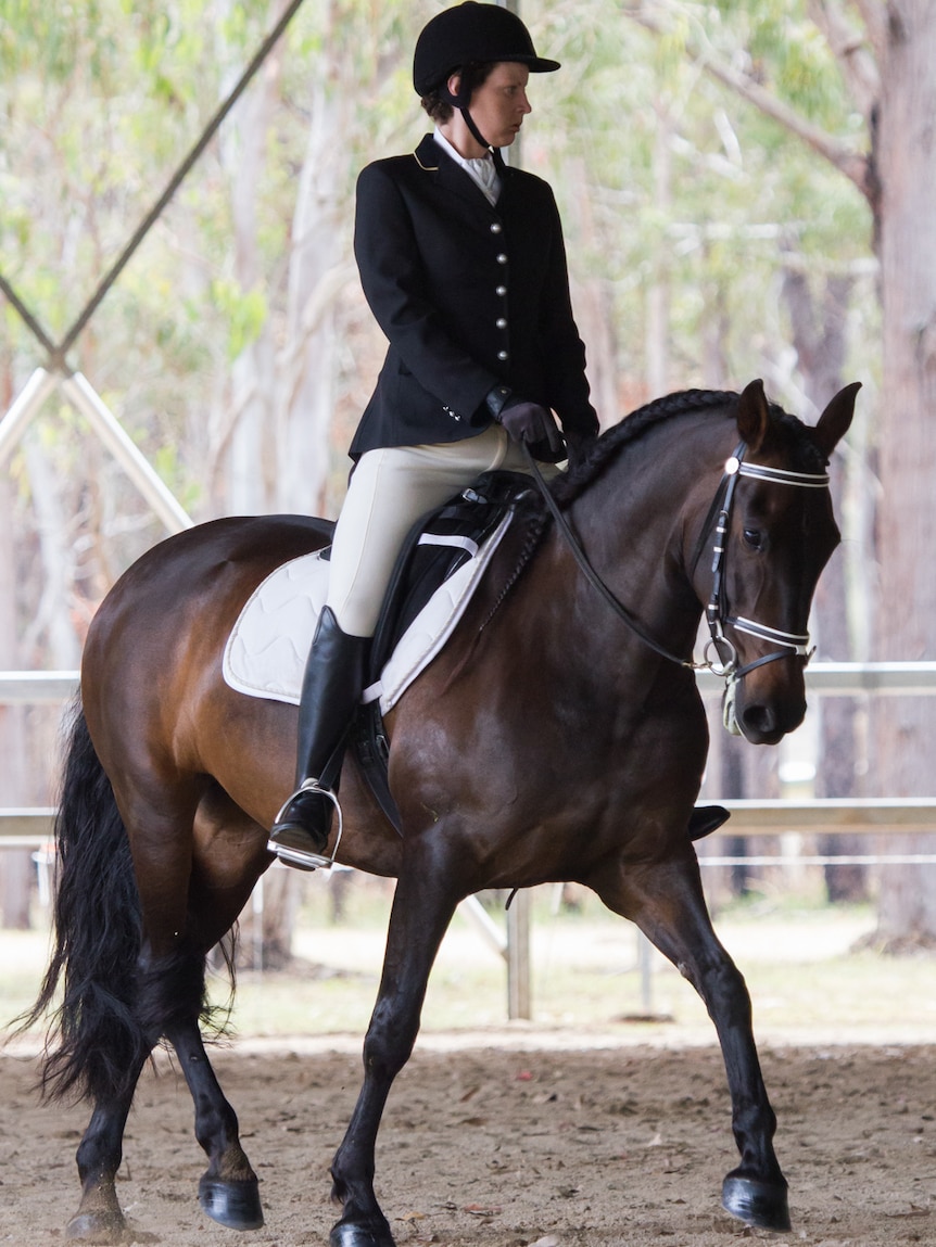 In dressage clothing, Danyele Foster rides in a competitive equestrian event on the Atherton Tablelands in far north Queensland.