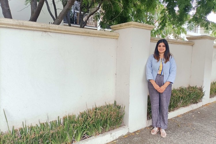 Khushi Malhotra standing outside the front fence of her apartment building.