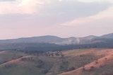 A landscape picture of rolling hills with a smokey haze.