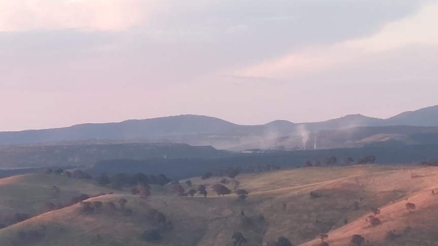 A landscape picture of rolling hills with a smokey haze.