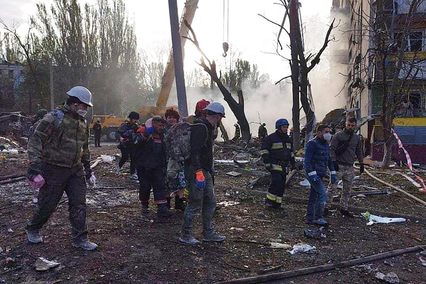 In questa foto fornita dal servizio di emergenza ucraino, i soccorritori lavorano sul sito di un edificio.