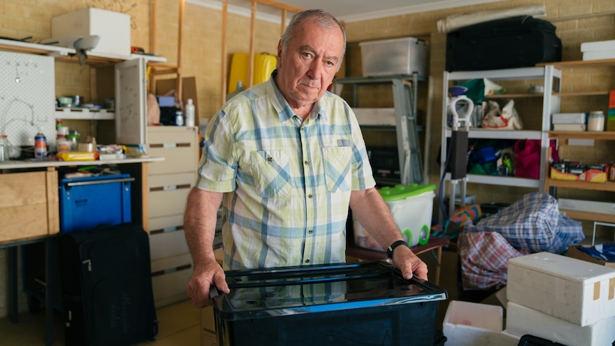 A man holding a black plastic box.